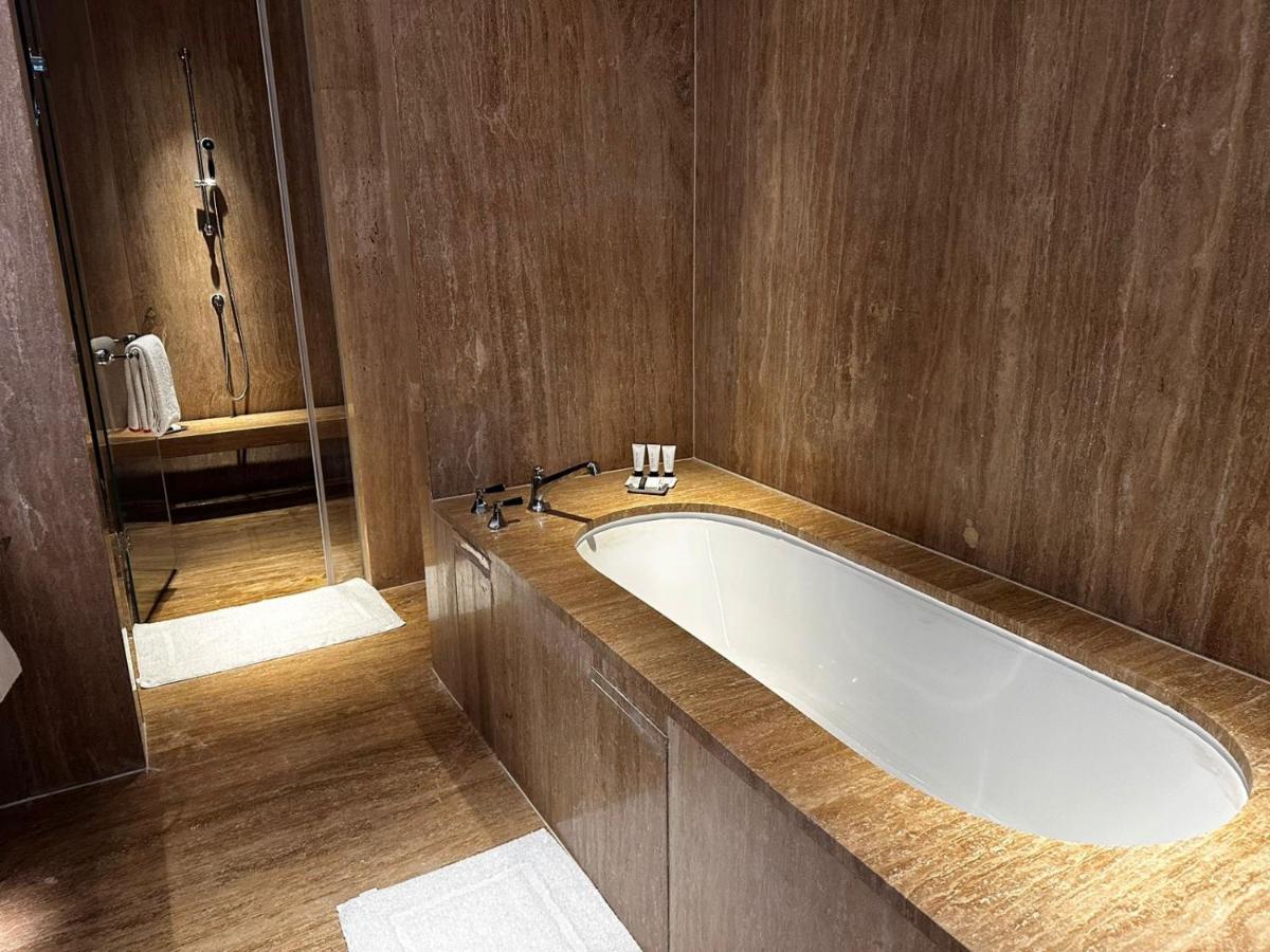 a bathroom with a bath tub and a shower at Grand Hyatt Gurgaon in Gurgaon