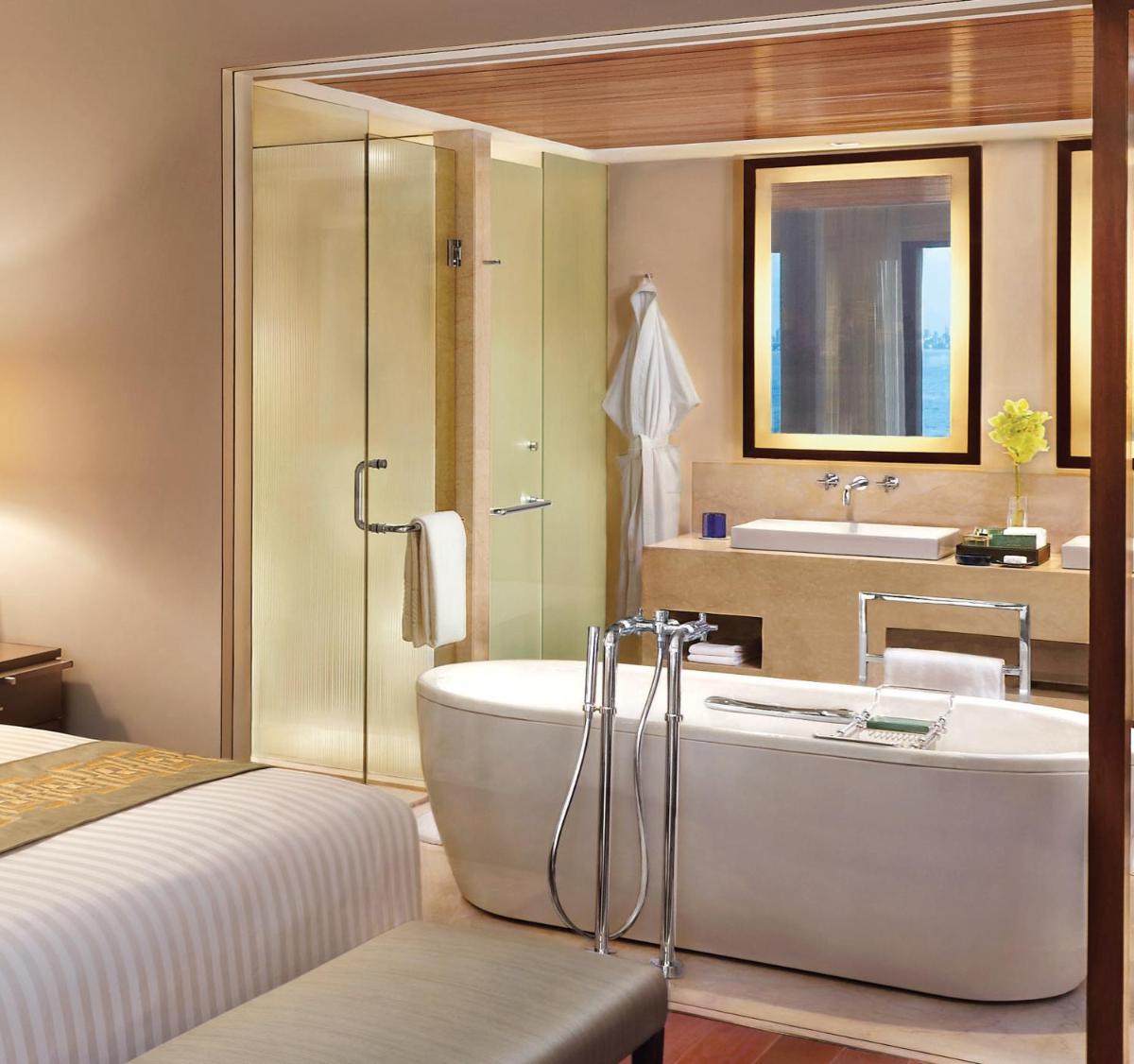 a bathroom with a tub and a bed and a sink at The Oberoi Mumbai in Mumbai