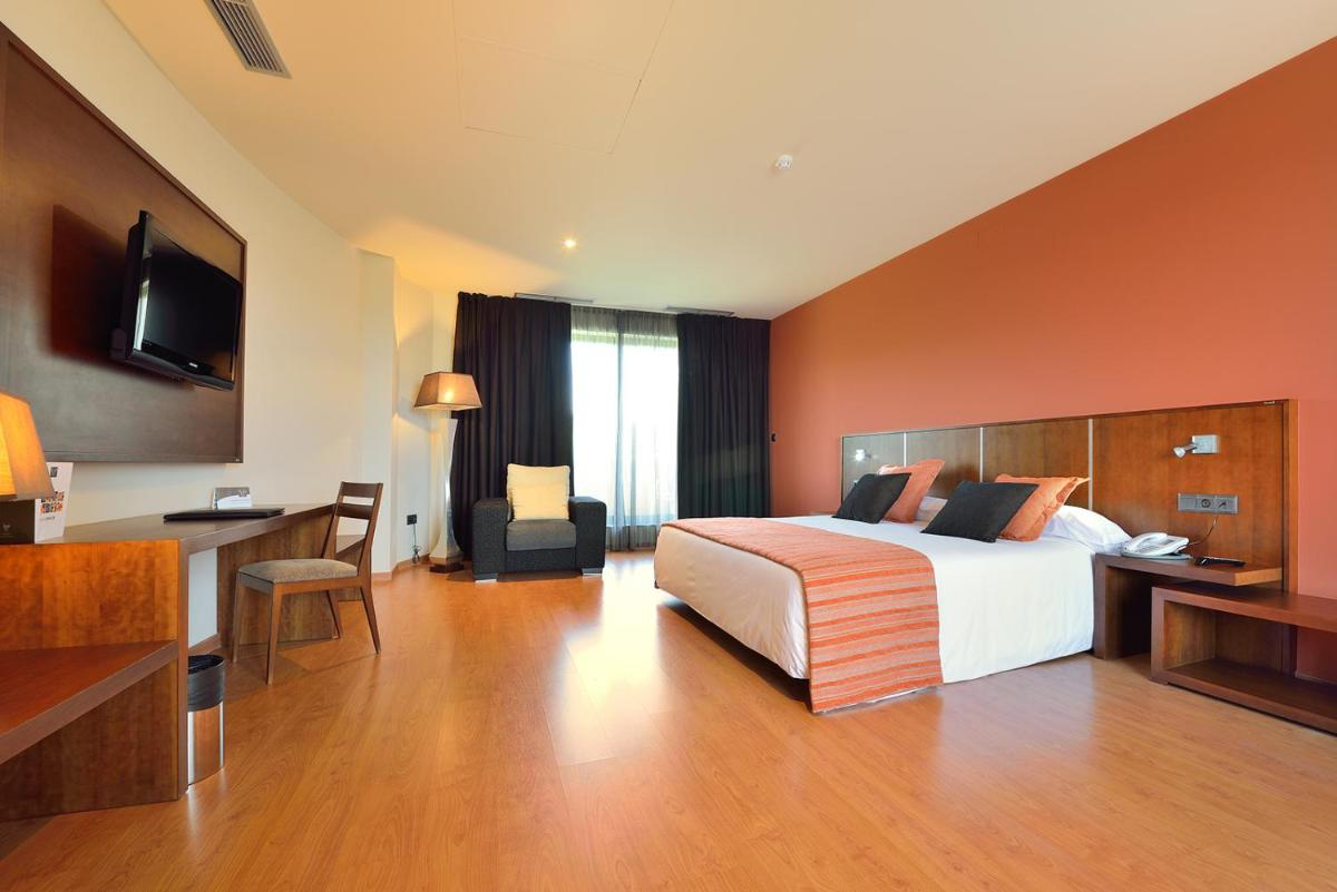 una habitación de hotel con una cama y un escritorio en Hotel Spa Norat Torre Do Deza 4* Superior, en Lalín