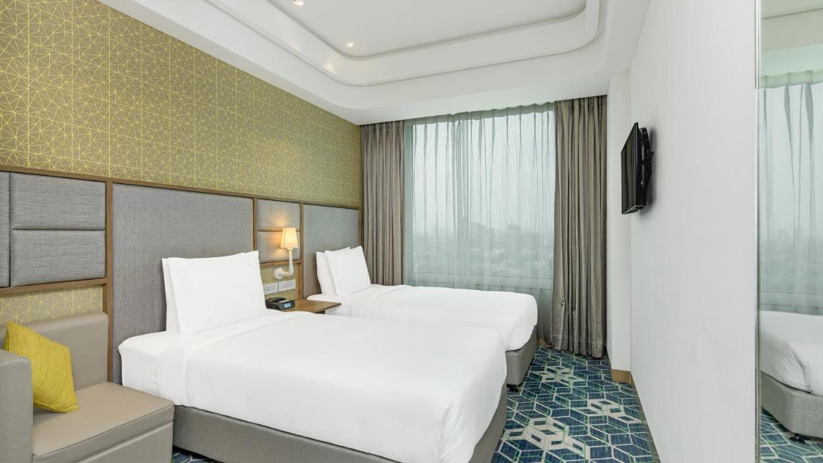 a hotel room with two beds and a television at Holiday Inn Gurugram Sector 90 by IHG in Gurgaon
