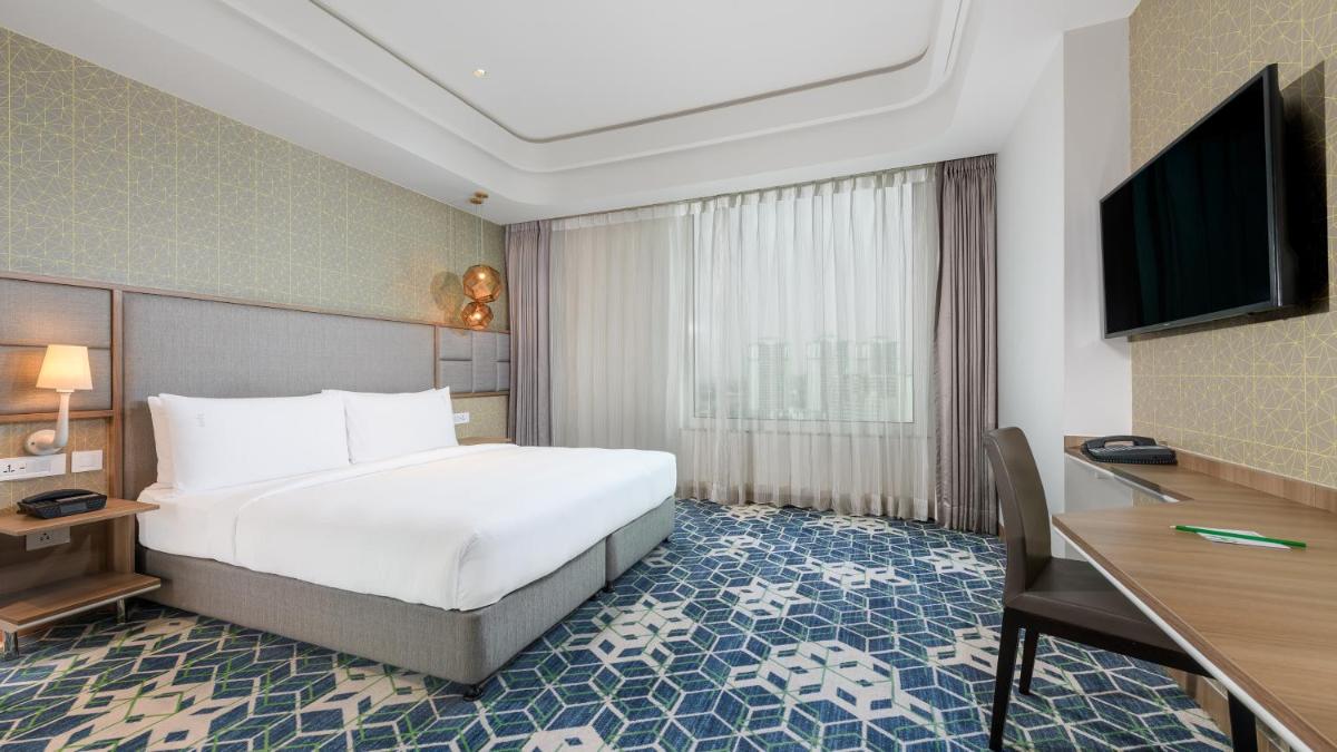 a hotel room with a bed and a flat screen tv at Holiday Inn Gurugram Sector 90 by IHG in Gurgaon