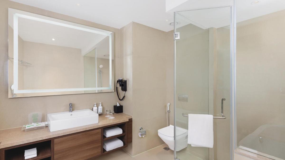 a bathroom with a toilet sink and a shower at Holiday Inn Gurugram Sector 90 by IHG in Gurgaon