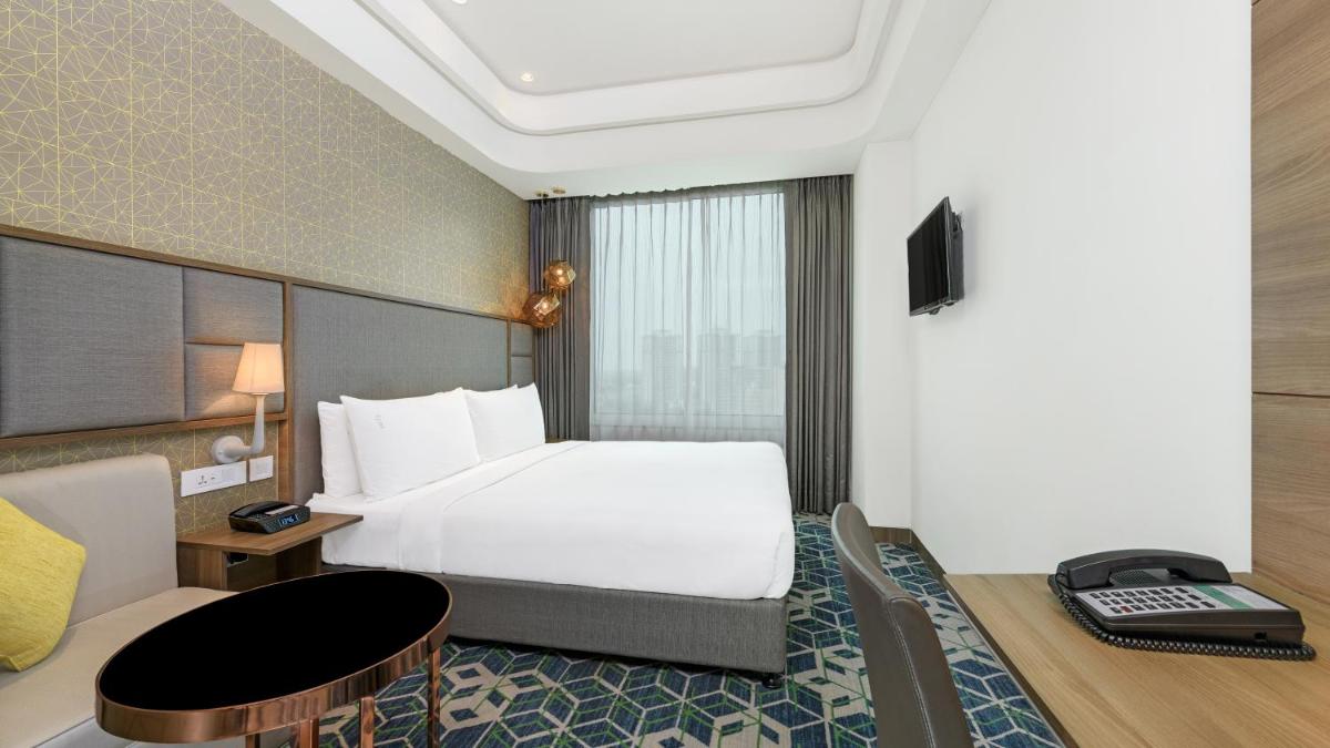 a hotel room with a bed and a desk at Holiday Inn Gurugram Sector 90 by IHG in Gurgaon