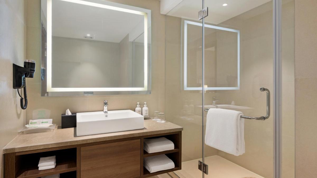 a bathroom with a sink and a glass shower at Holiday Inn Gurugram Sector 90 by IHG in Gurgaon