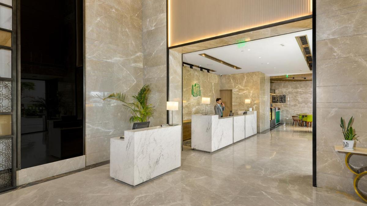 a lobby with a row of white reception desks at Holiday Inn Gurugram Sector 90 by IHG in Gurgaon