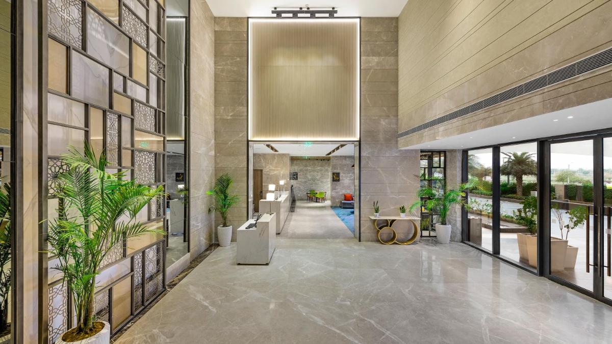 a lobby with potted plants in a building at Holiday Inn Gurugram Sector 90 by IHG in Gurgaon