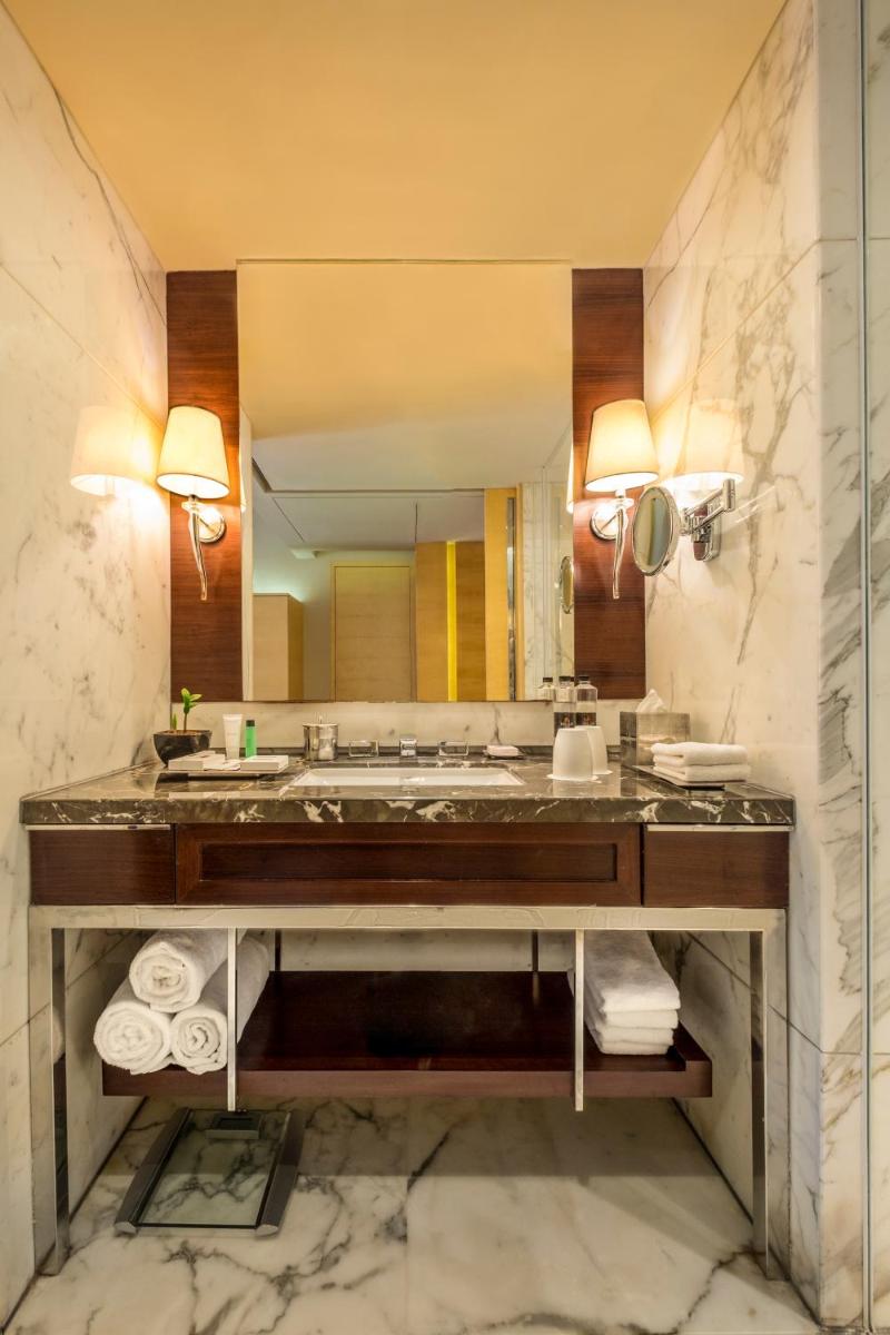 a bathroom with a sink and a large mirror at JW Marriott Mumbai Juhu in Mumbai