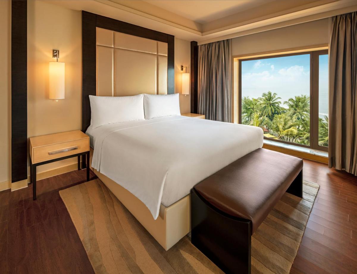 a bedroom with a large bed and a large window at JW Marriott Mumbai Juhu in Mumbai