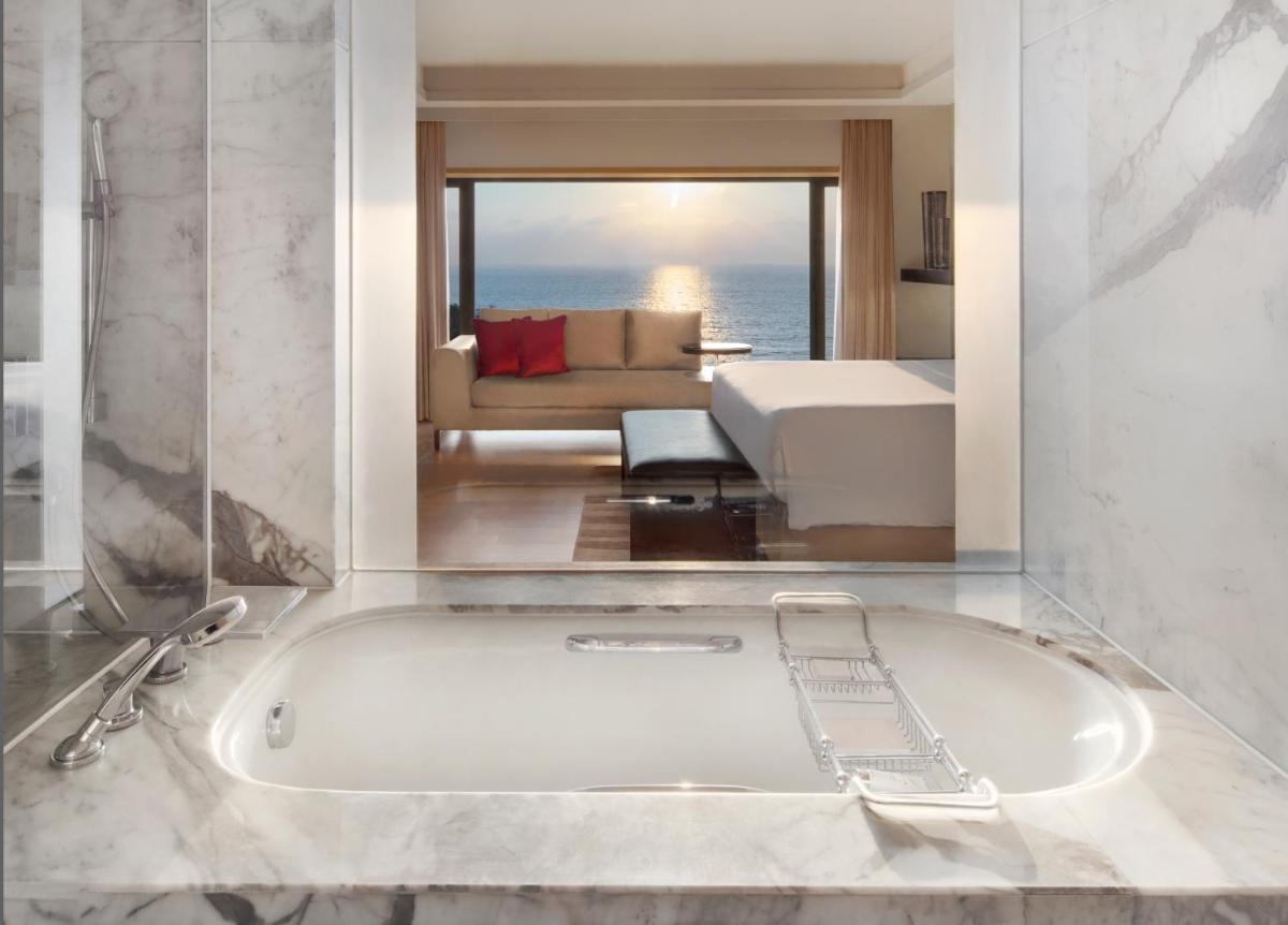a bathroom with a bath tub and a living room at JW Marriott Mumbai Juhu in Mumbai