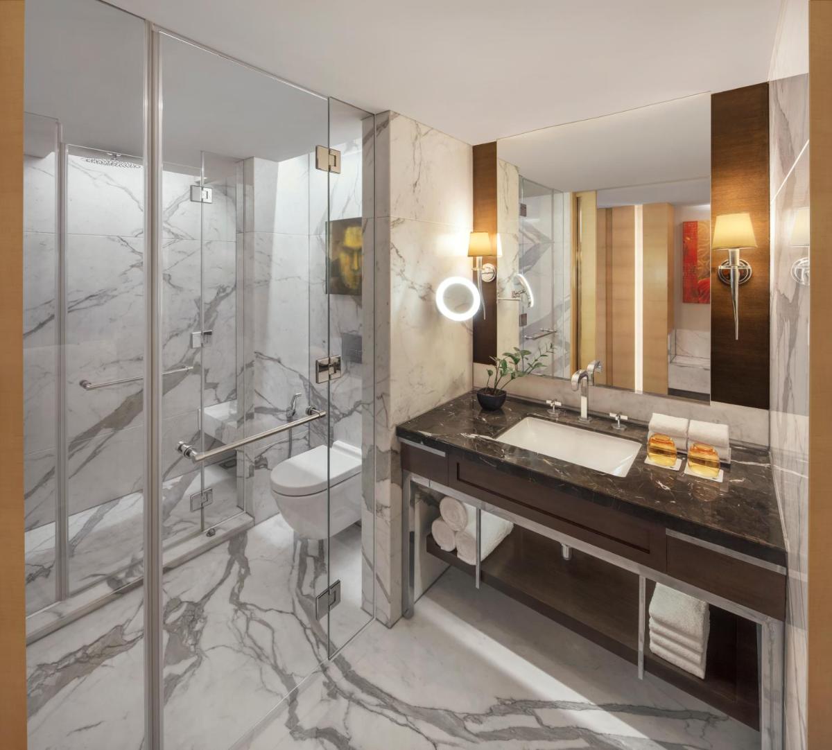 a bathroom with a sink and a toilet and a shower at JW Marriott Mumbai Juhu in Mumbai