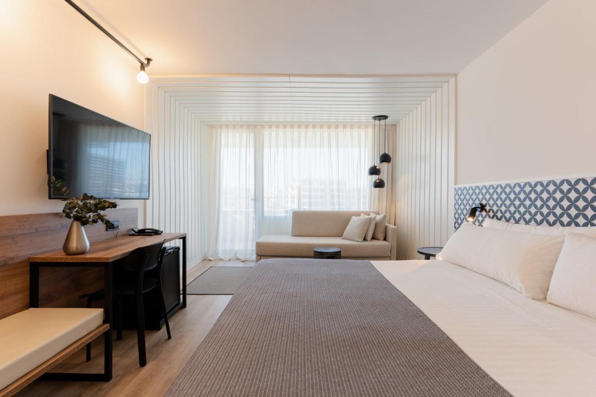 Un dormitorio con una cama, un escritorio y un sofá. en Magnolia Hotel - Adults Only, en Salou