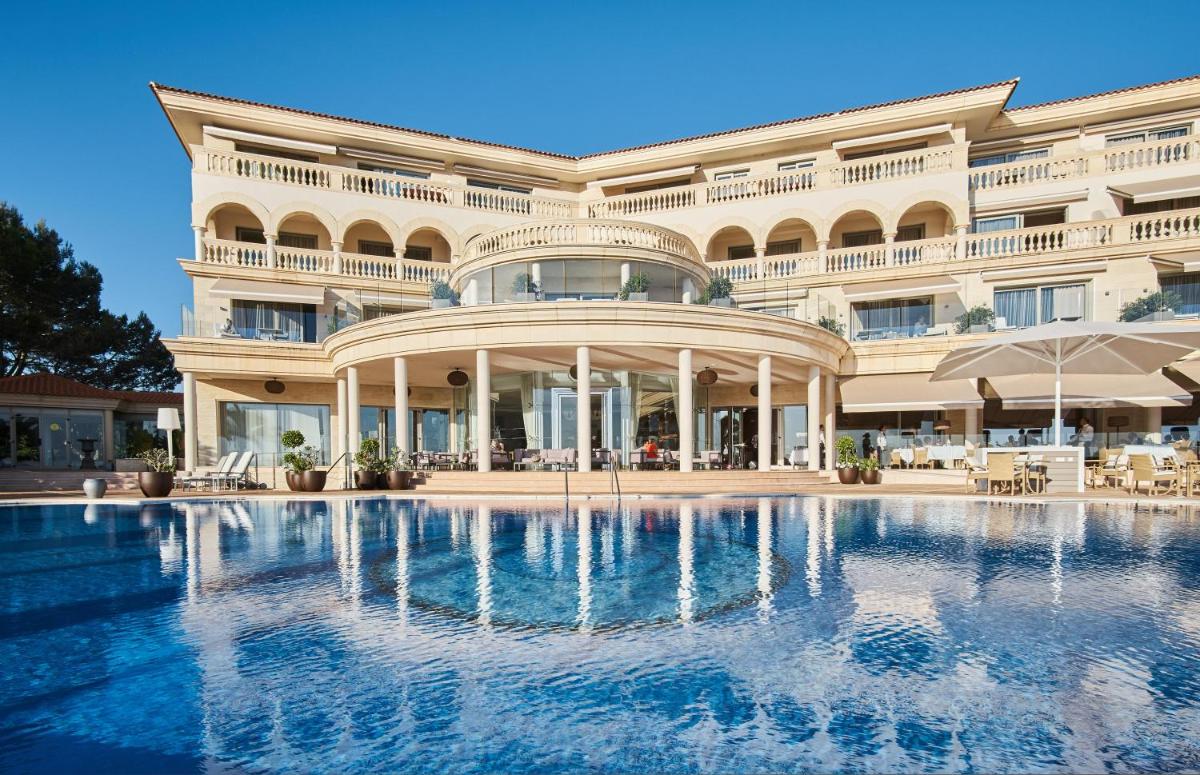 Un gran edificio con una piscina en frente. en Pure Salt Port Adriano - Adults Only, en Santa Ponsa