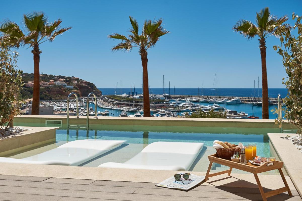 una piscina con palmeras y vistas al puerto deportivo en Pure Salt Port Adriano - Adults Only, en Santa Ponsa