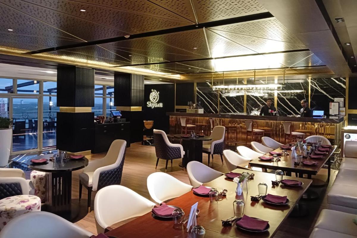 a dining room with tables and white chairs at Crowne Plaza Kochi by IHG in Cochin