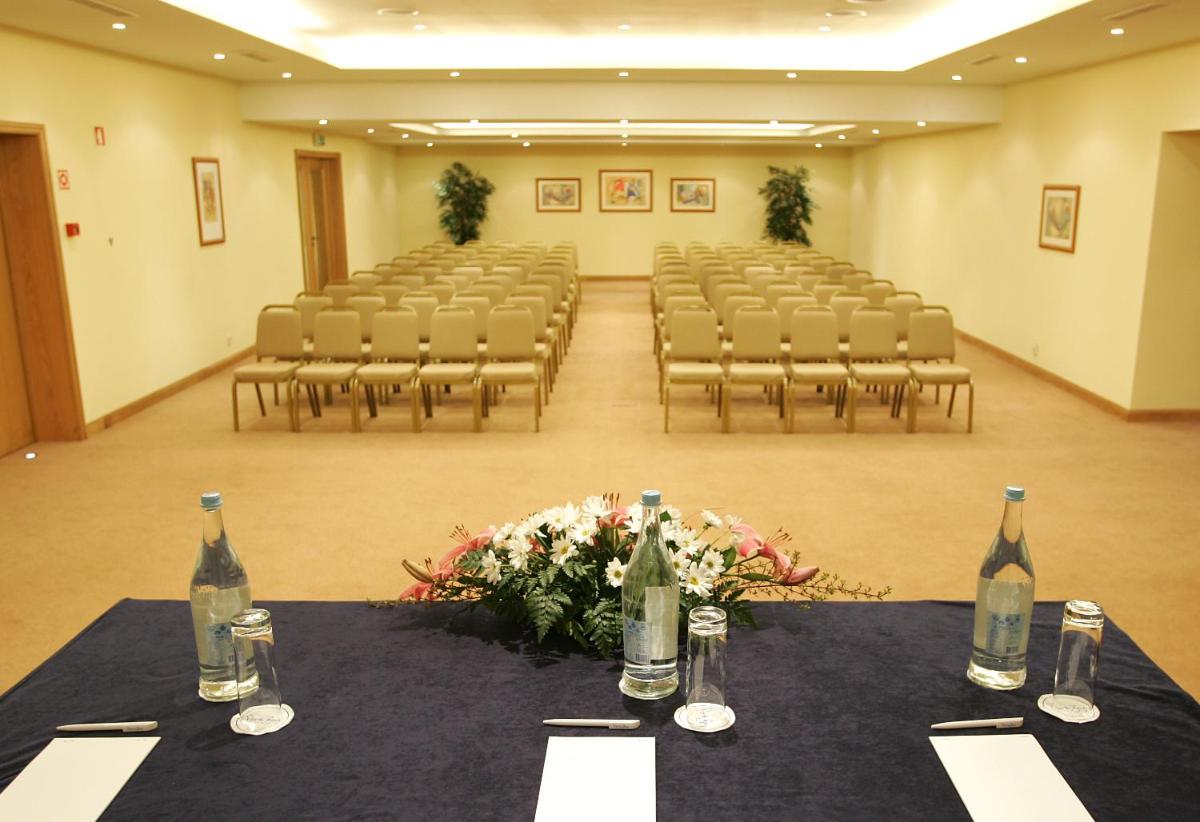 uma sala vazia com cadeiras e garrafas de vinho sobre uma mesa em The Residence Porto Mare - PortoBay no Funchal