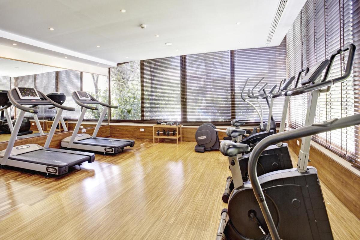 un gimnasio con varias cintas de correr y máquinas elípticas en Grupotel Nilo & Spa, en Paguera