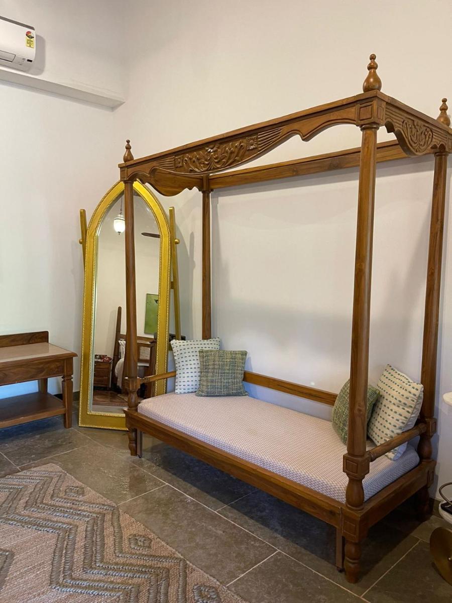 a canopy bed in a room with a mirror at The Postcard Saligao in Calangute