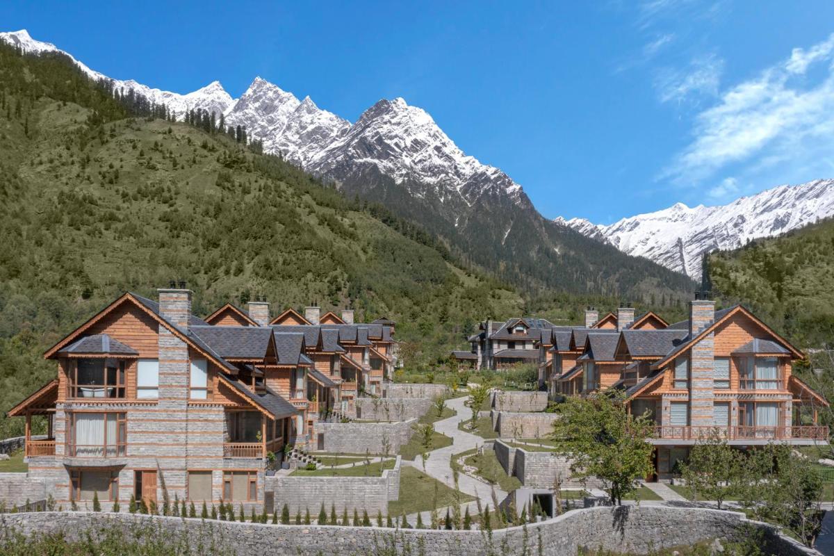 a row of houses in front of a mountain at Welcomhotel By ITC Hotels, Hamsa Manali in Manāli a row of houses in front of a mountain at Welcomhotel By ITC Hotels, Hamsa Manali in Manāli