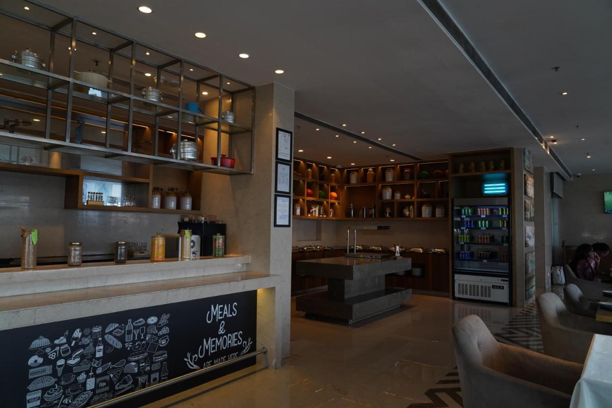 a restaurant with a bar with a sink and a counter at Marriott Executive Apartments Hyderabad in Hyderabad