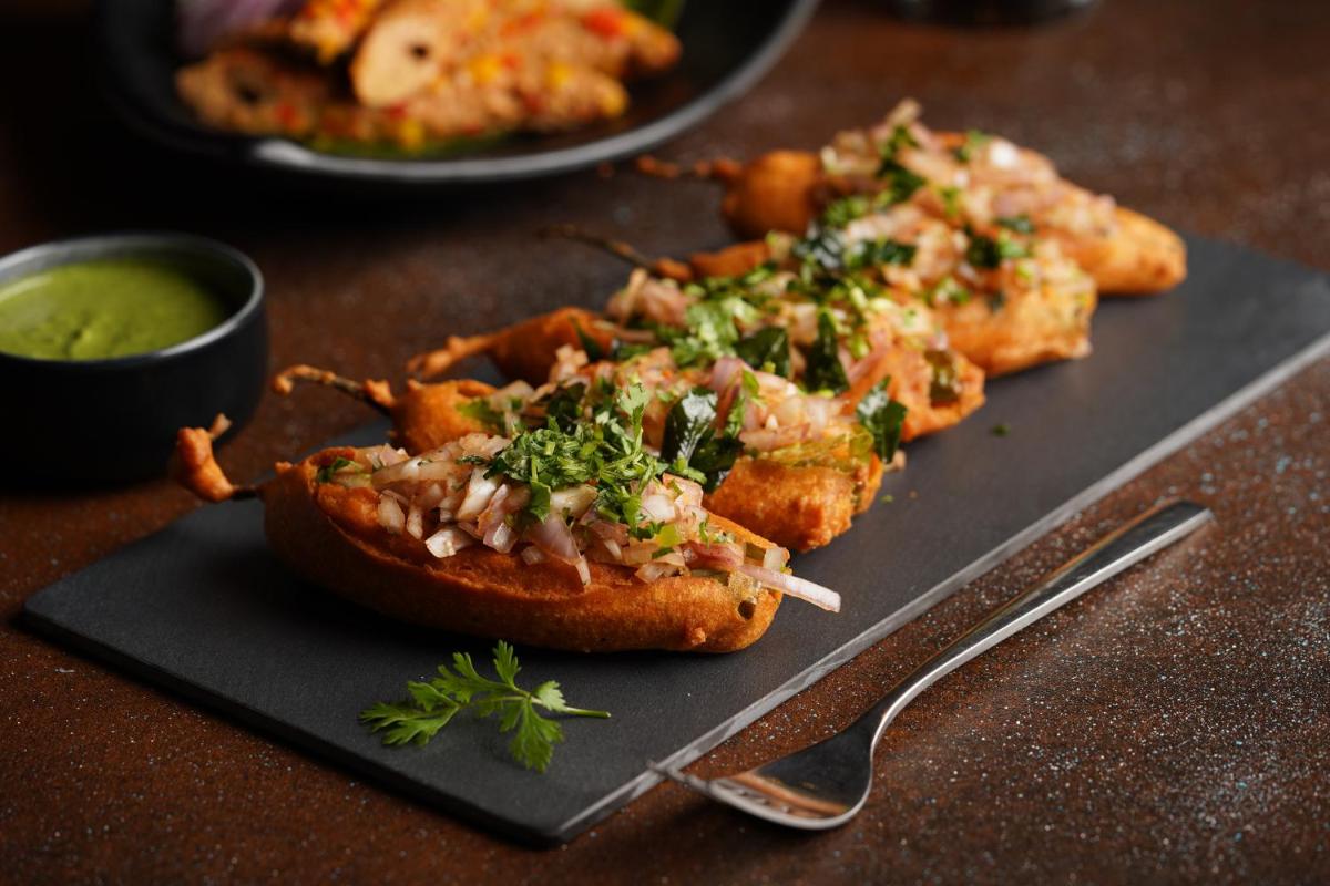 a black plate with some food on a table at Marriott Executive Apartments Hyderabad in Hyderabad