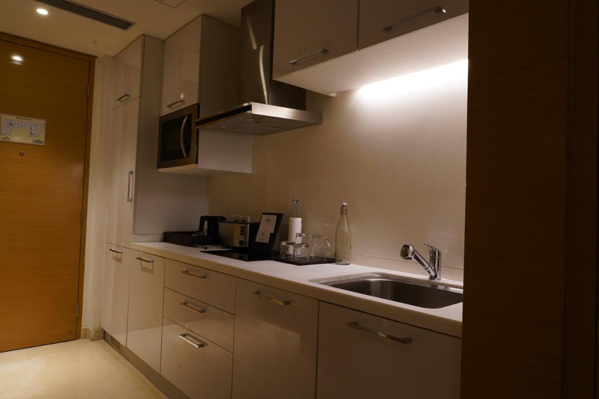 a kitchen with a sink and a microwave at Marriott Executive Apartments Hyderabad in Hyderabad