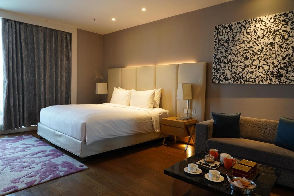 a hotel room with a bed and a couch at Marriott Executive Apartments Hyderabad in Hyderabad