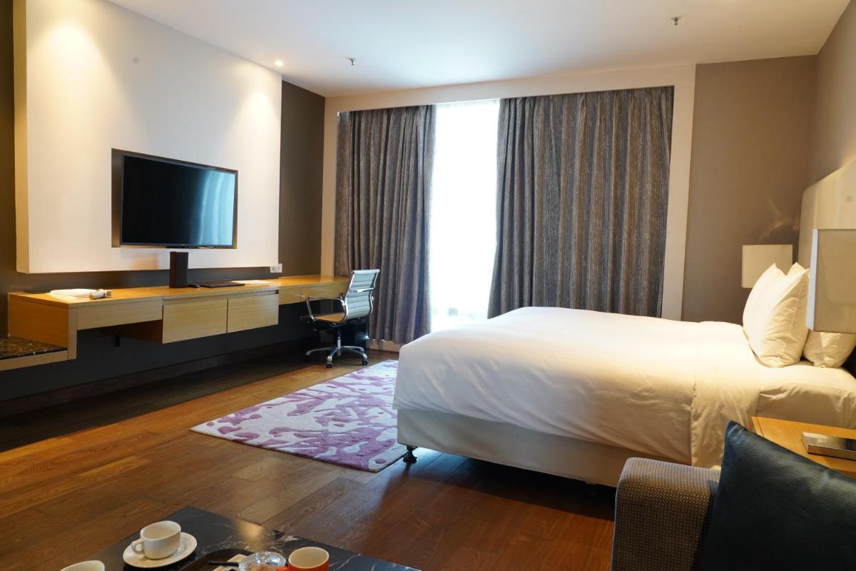 a hotel room with a bed and a flat screen tv at Marriott Executive Apartments Hyderabad in Hyderabad