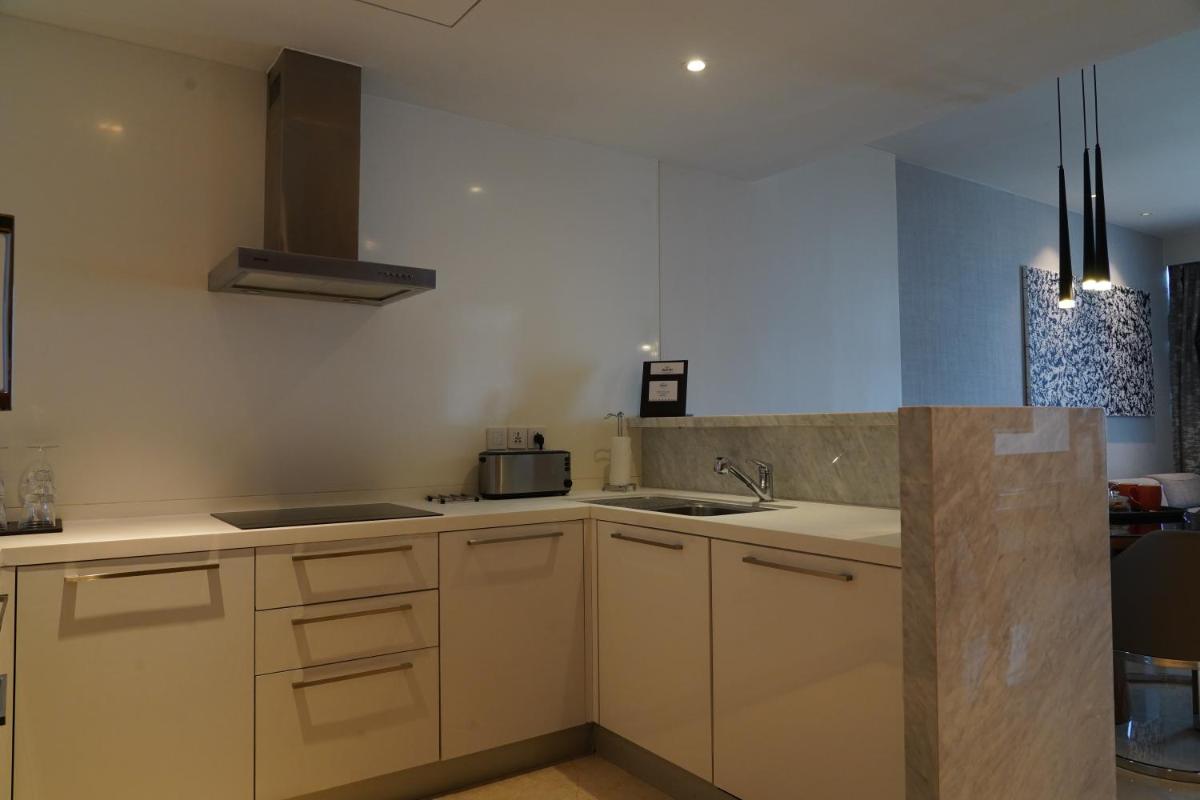 a kitchen with white cabinets and a sink at Marriott Executive Apartments Hyderabad in Hyderabad