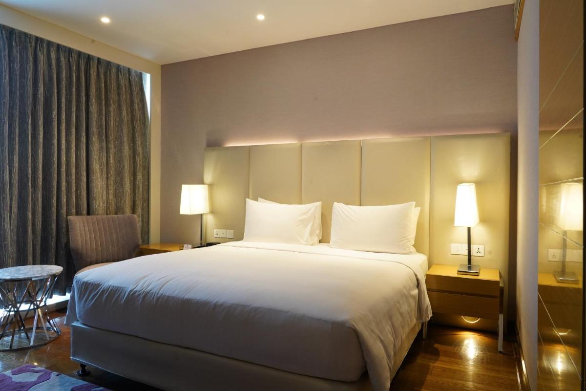 a hotel room with a large bed with white pillows at Marriott Executive Apartments Hyderabad in Hyderabad