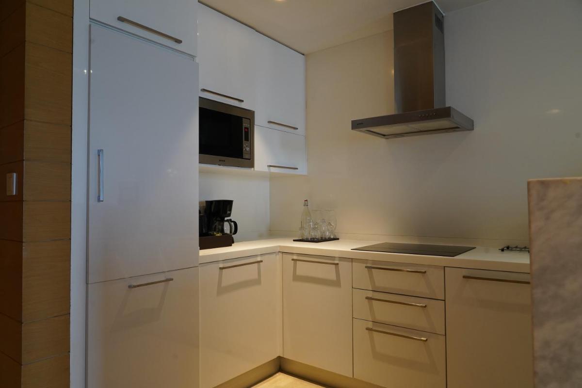 a kitchen with white cabinets and a microwave at Marriott Executive Apartments Hyderabad in Hyderabad