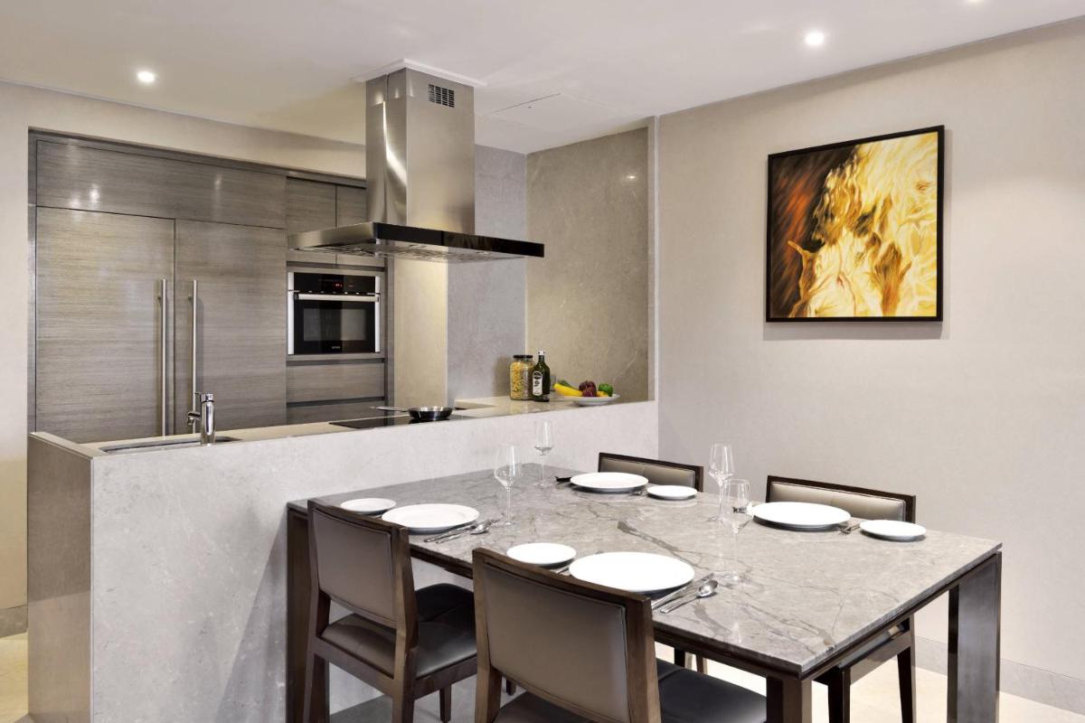 a dining room with a table and chairs in a kitchen at JW Marriott Mumbai Sahar Airport in Mumbai a dining room with a table and chairs in a kitchen at JW Marriott Mumbai Sahar Airport in Mumbai