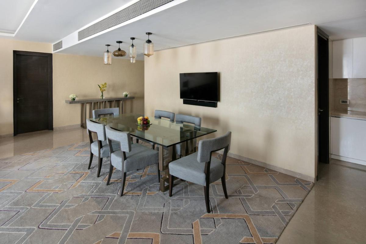 a dining room with a table and chairs at JW Marriott Mumbai Sahar Airport in Mumbai a dining room with a table and chairs at JW Marriott Mumbai Sahar Airport in Mumbai