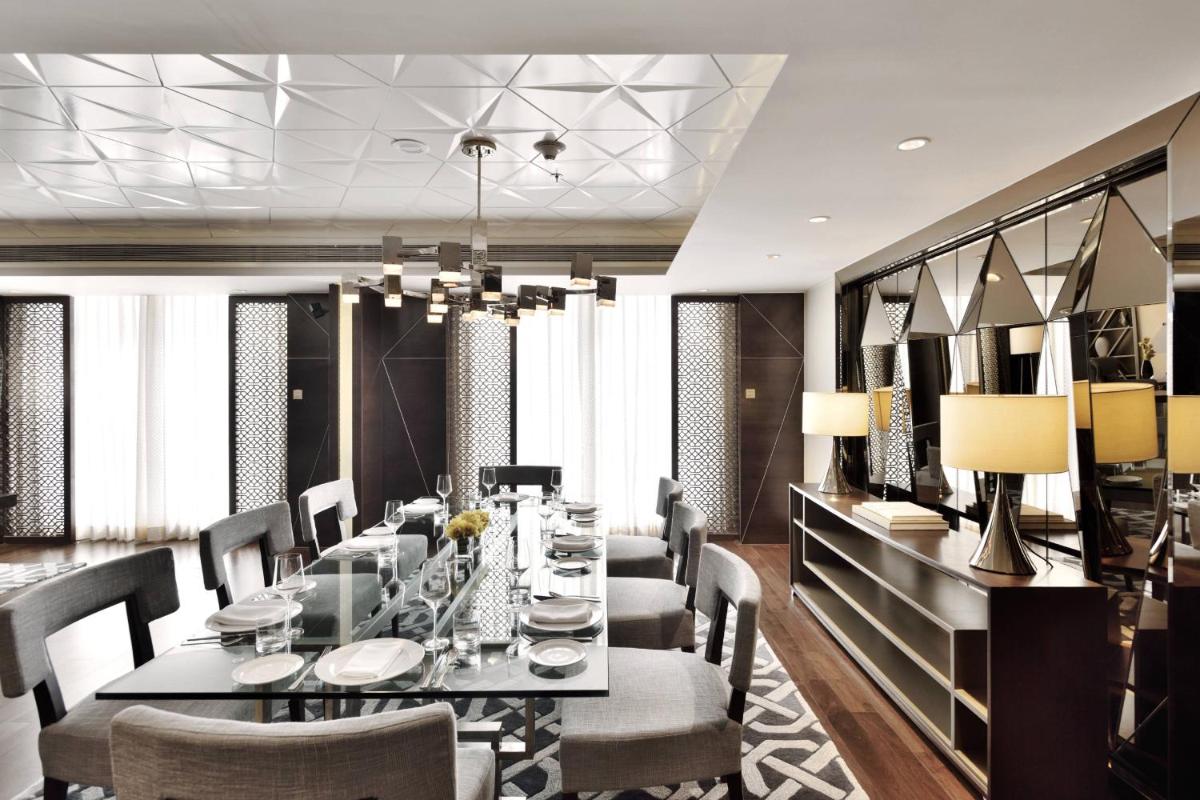 a dining room with a long table and chairs at JW Marriott Mumbai Sahar Airport in Mumbai a dining room with a long table and chairs at JW Marriott Mumbai Sahar Airport in Mumbai
