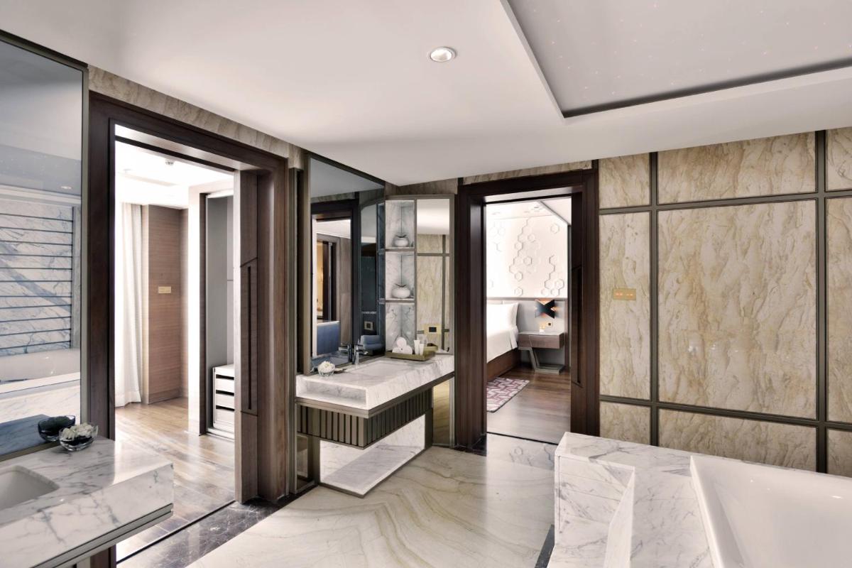 a bathroom with a tub and a sink at JW Marriott Mumbai Sahar Airport in Mumbai a bathroom with a tub and a sink at JW Marriott Mumbai Sahar Airport in Mumbai