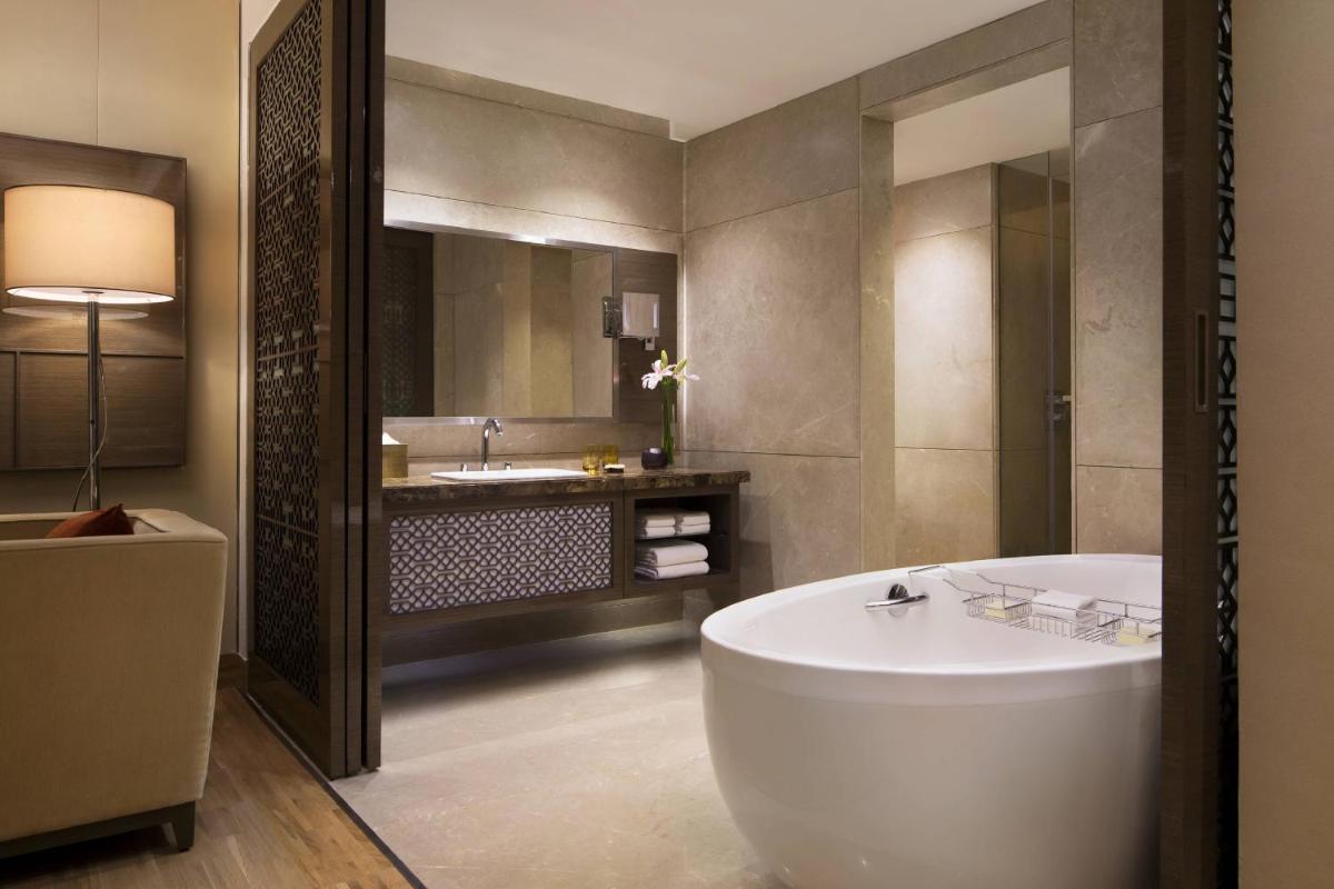 a bathroom with a large tub and a sink at JW Marriott Mumbai Sahar Airport in Mumbai a bathroom with a large tub and a sink at JW Marriott Mumbai Sahar Airport in Mumbai