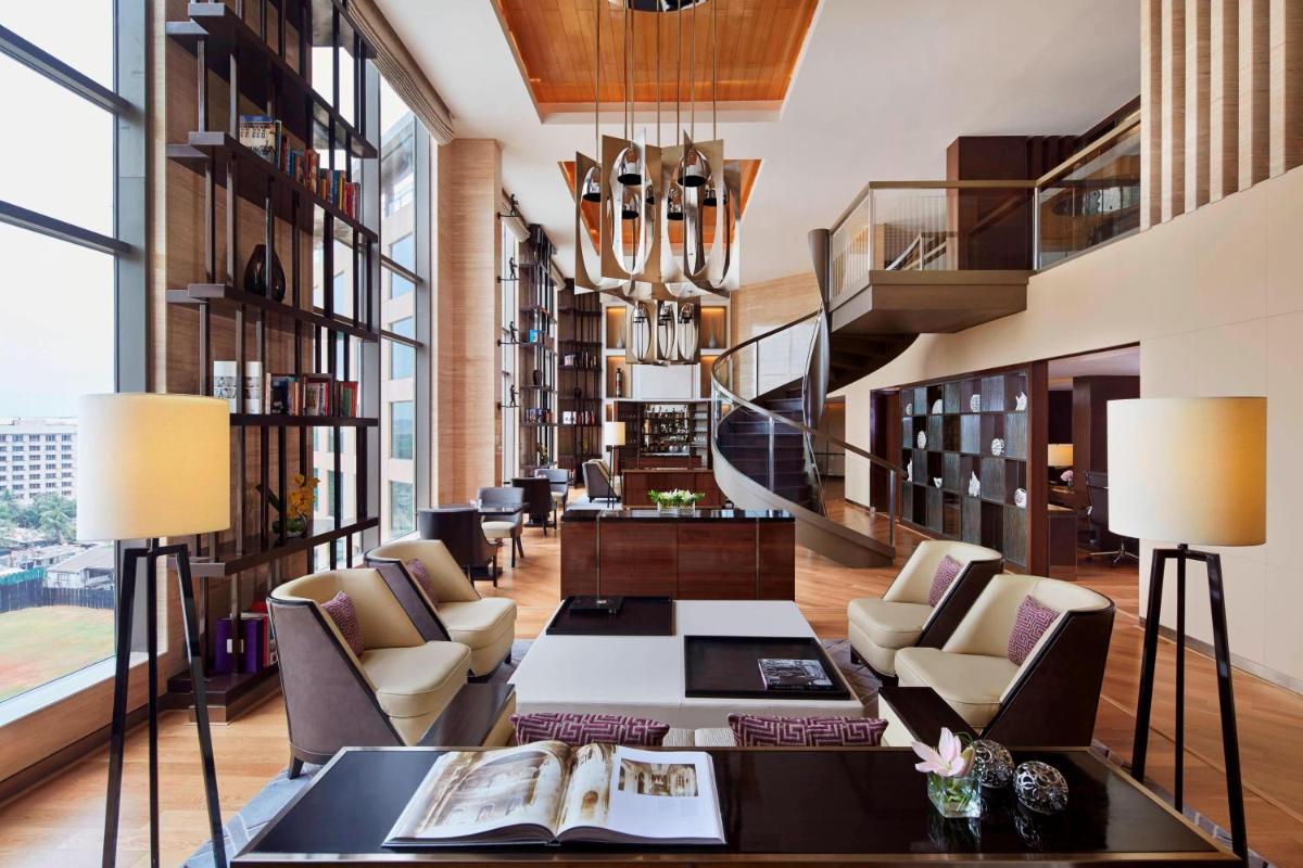 a living room filled with furniture and a chandelier at JW Marriott Mumbai Sahar Airport in Mumbai a living room filled with furniture and a chandelier at JW Marriott Mumbai Sahar Airport in Mumbai