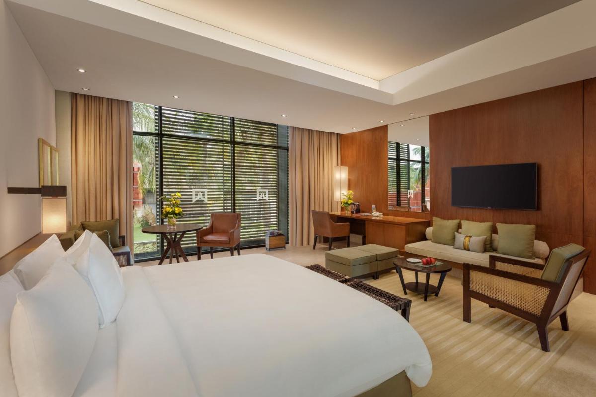 a bedroom with a large white bed and a living room at ITC Sonar, a Luxury Collection Hotel, Kolkata in Kolkata