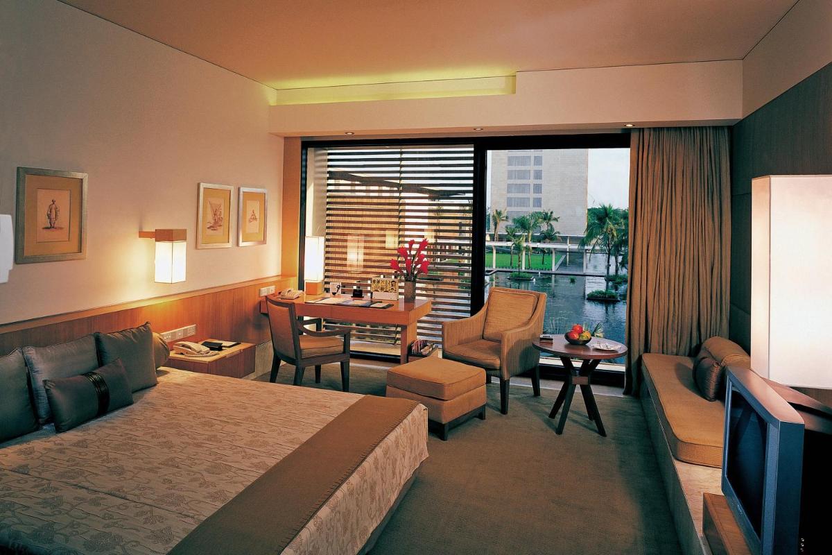 a hotel room with a bed and a dining room at ITC Sonar, a Luxury Collection Hotel, Kolkata in Kolkata