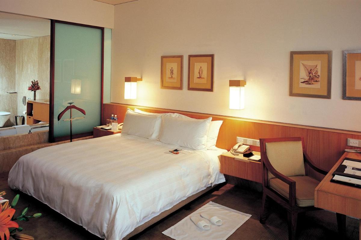 a hotel room with a bed and a desk and a chair at ITC Sonar, a Luxury Collection Hotel, Kolkata in Kolkata