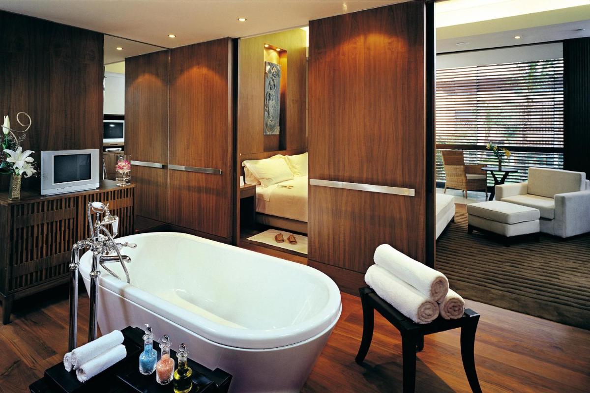 a bathroom with a bath tub and a bedroom at ITC Sonar, a Luxury Collection Hotel, Kolkata in Kolkata