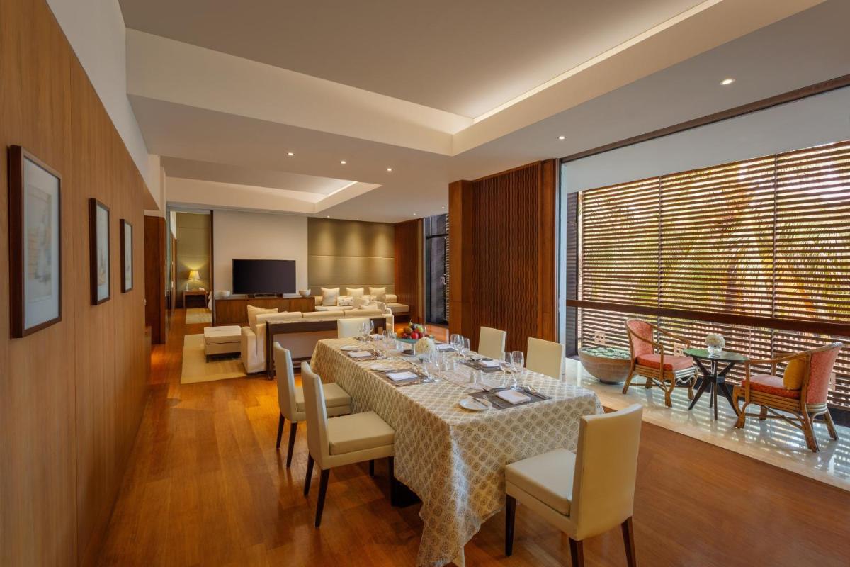 a dining room with a table and chairs and a living room at ITC Sonar, a Luxury Collection Hotel, Kolkata in Kolkata