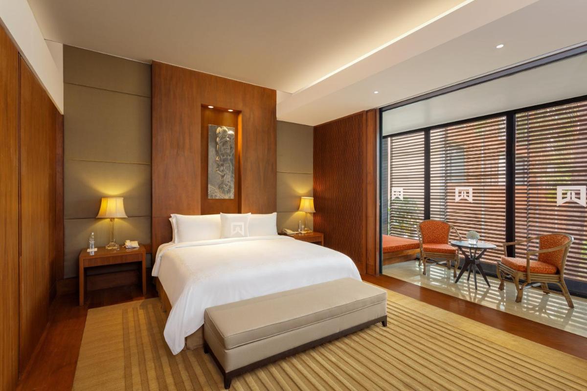 a bedroom with a white bed and a large window at ITC Sonar, a Luxury Collection Hotel, Kolkata in Kolkata
