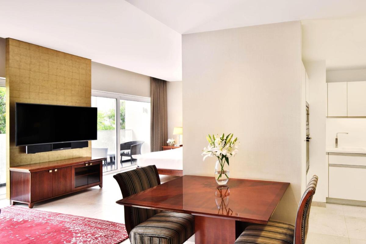 a living room with a table and a tv at Marriott Suites Pune in Pune