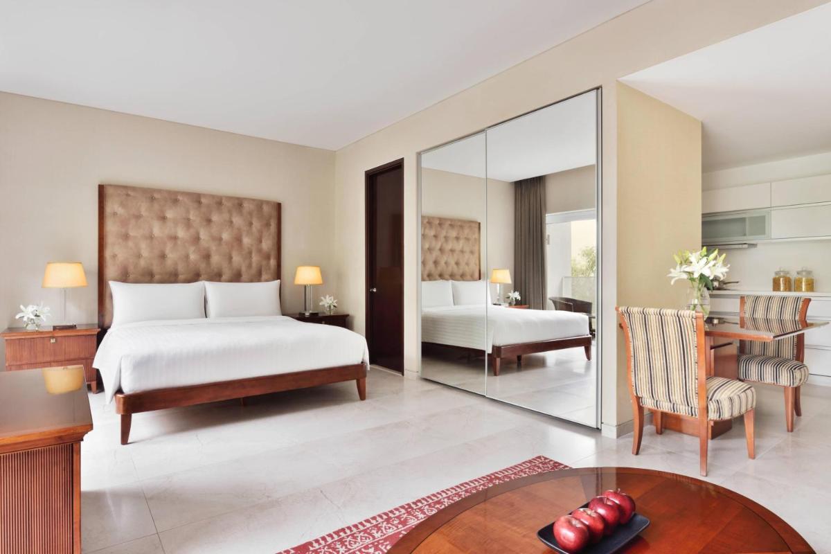 a bedroom with a bed and a desk and a table at Marriott Suites Pune in Pune