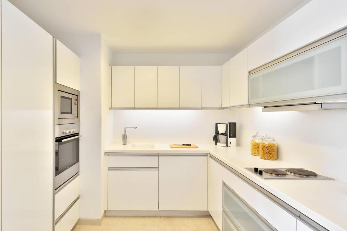 a white kitchen with white cabinets and appliances at Marriott Suites Pune in Pune