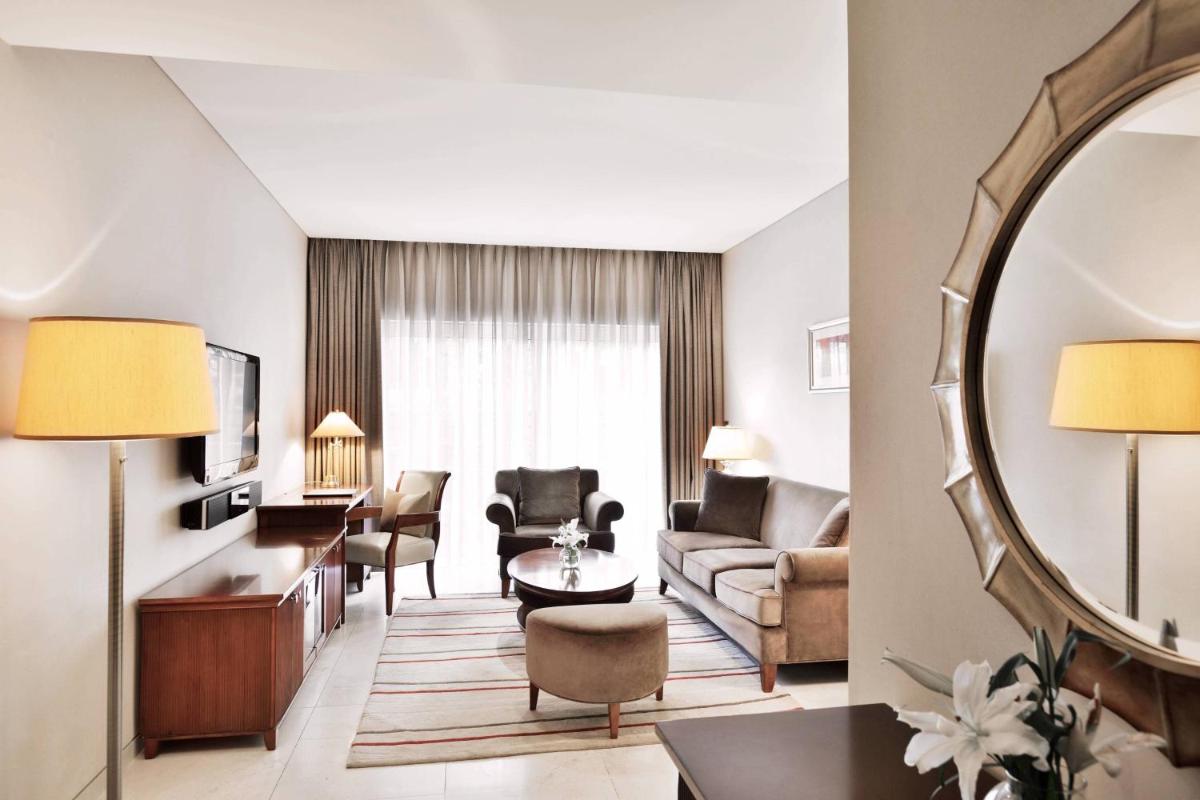 a living room with a couch and a mirror at Marriott Suites Pune in Pune