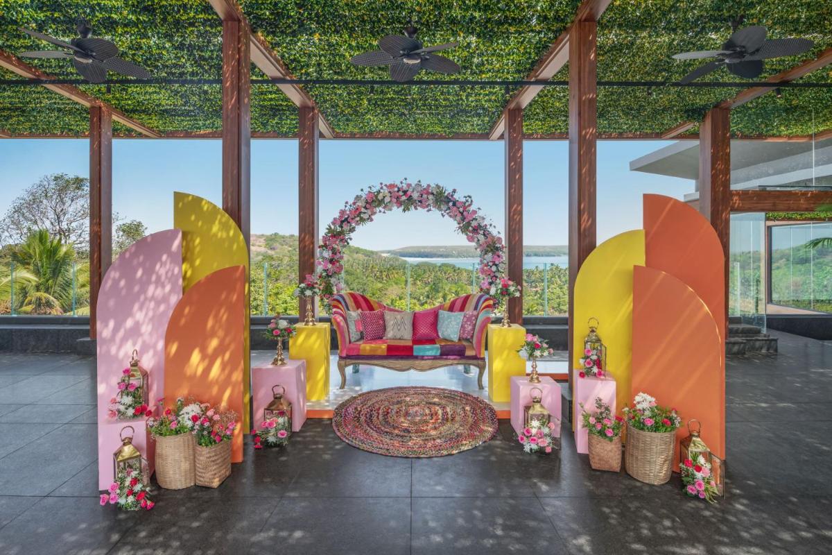 a wedding reception in a pavilion with an arch and flowers at JW Marriott Goa in Vagator a wedding reception in a pavilion with an arch and flowers at JW Marriott Goa in Vagator