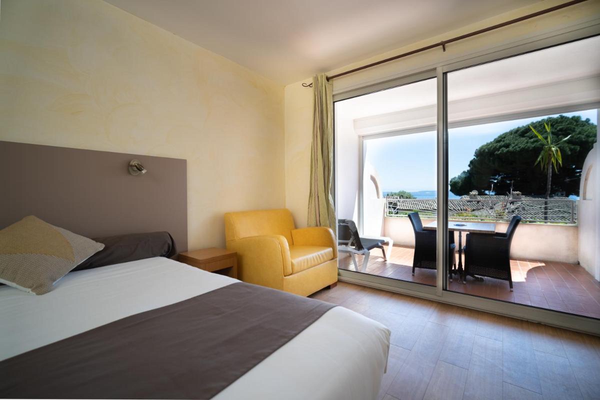une chambre d'hôtel avec un lit et une grande fenêtre dans l'établissement Hôtel Beau Soleil, au Lavandou 168 autres photos