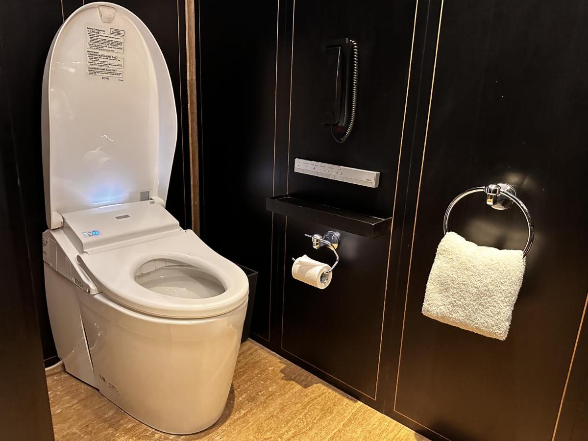 a bathroom with a toilet and a roll of toilet paper at Grand Hyatt Gurgaon in Gurgaon
