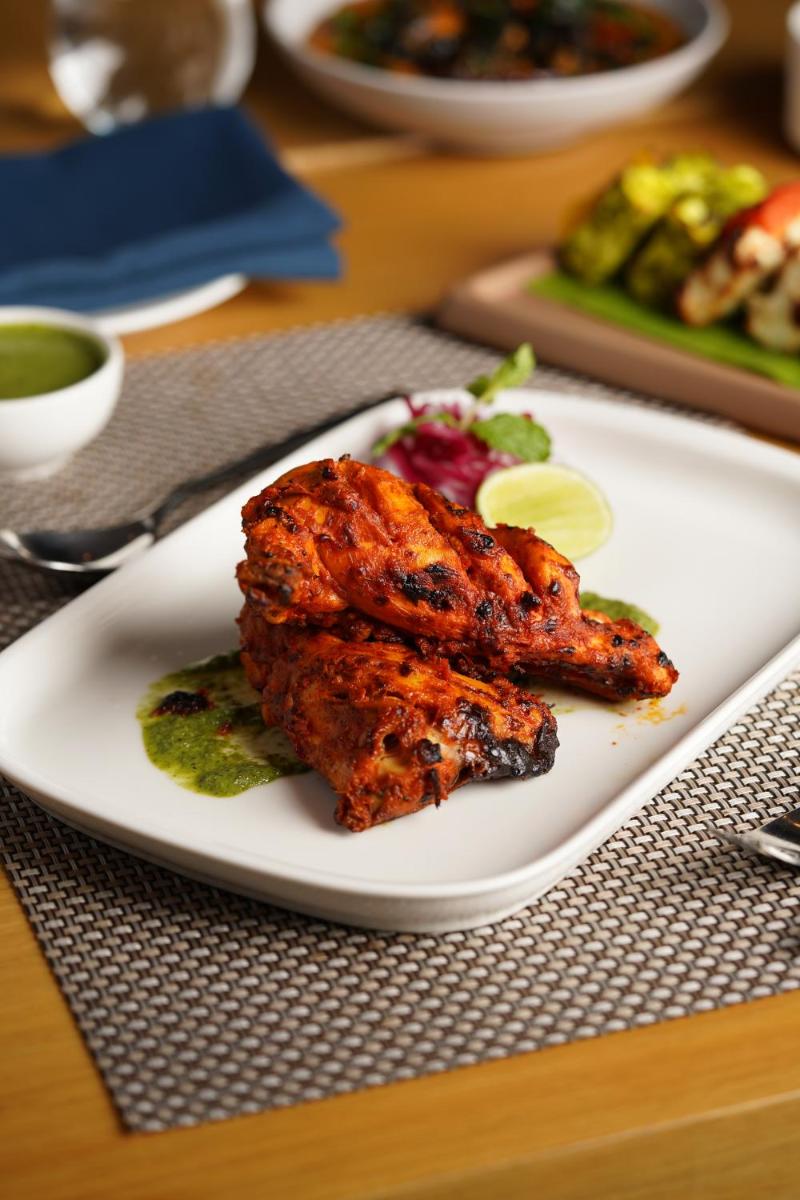 a white plate with two pieces of food on a table at Marriott Executive Apartments Hyderabad in Hyderabad